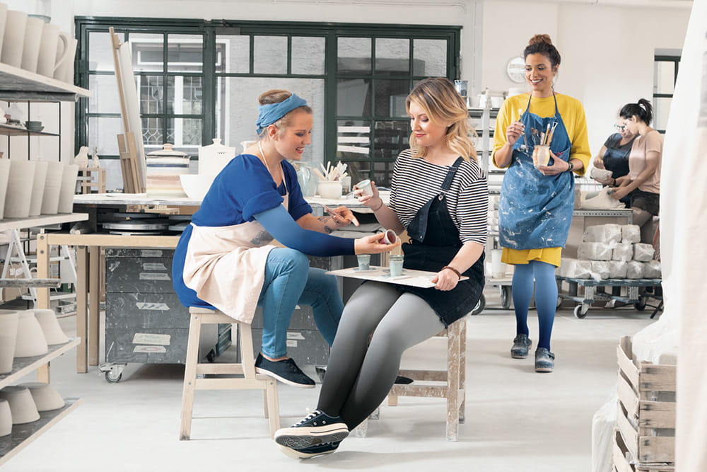 Einige Frauen arbeiten in der Töpferei und tragen dabei Kompressionsstrümpfe.