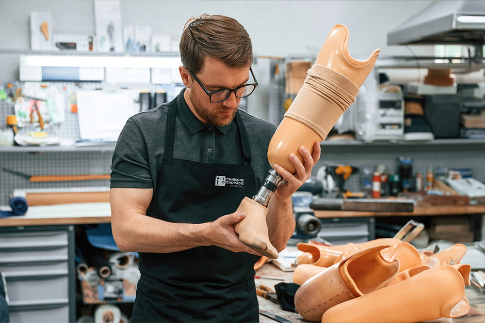 Ein Orthopädie-Techniker bei der Arbeit, wie er eine Prothese fertigt.